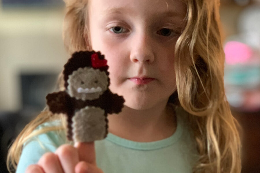 A child with a sasquatch finger puppet