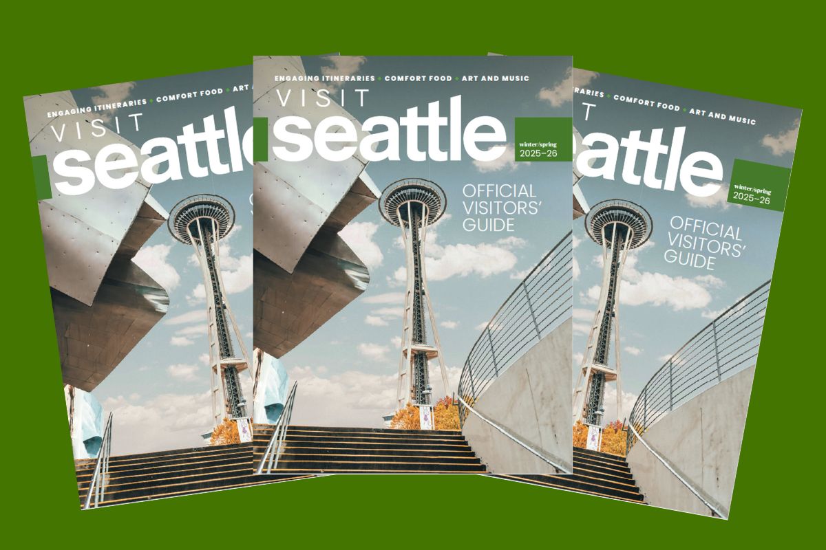 hree copies of the "Visit Seattle: Official Visitors' Guide" magazine are displayedfeaturing a cover photo of the Space Needle against a partly cloudy skywith railings and steps in the foreground.