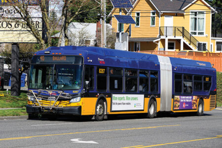 A blue and yellow articulated city bus marked 