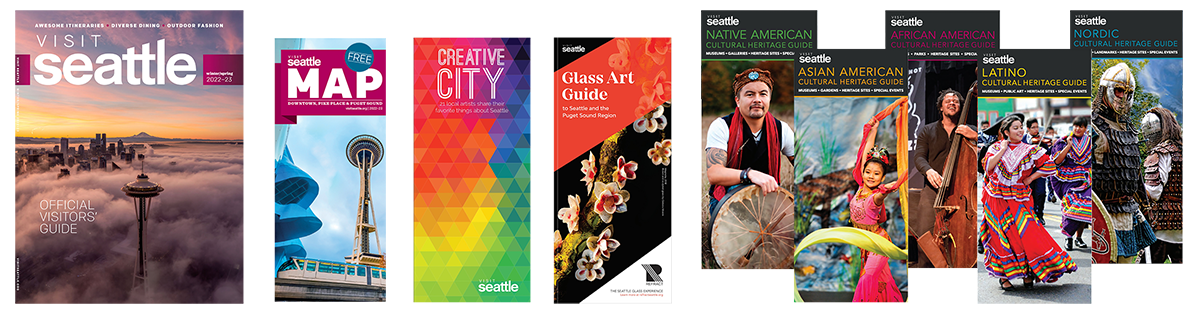 A row of colorful Seattle visitor magazines and brochures, including an official guide, maps, and cultural heritage guides, each featuring vibrant photos of attractions and diverse cultural celebrations.